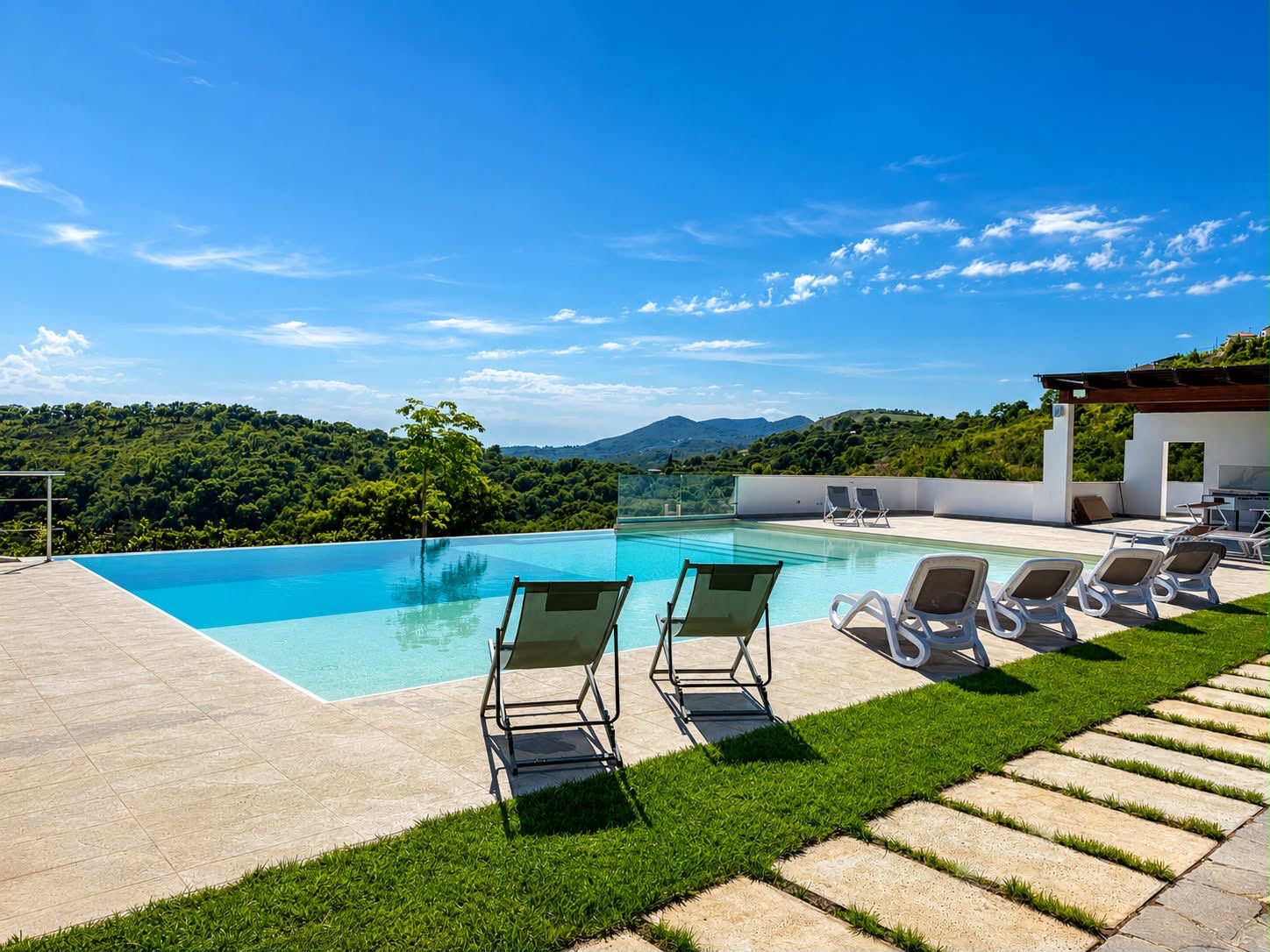 Piscina a sfioro con lettini e vista colline