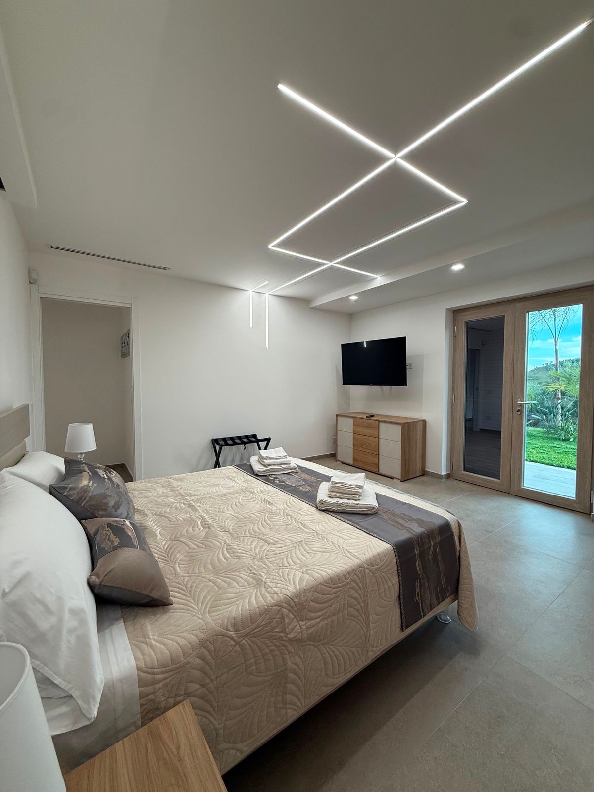 Camera matrimoniale con LED a soffitto a disegno geometrico