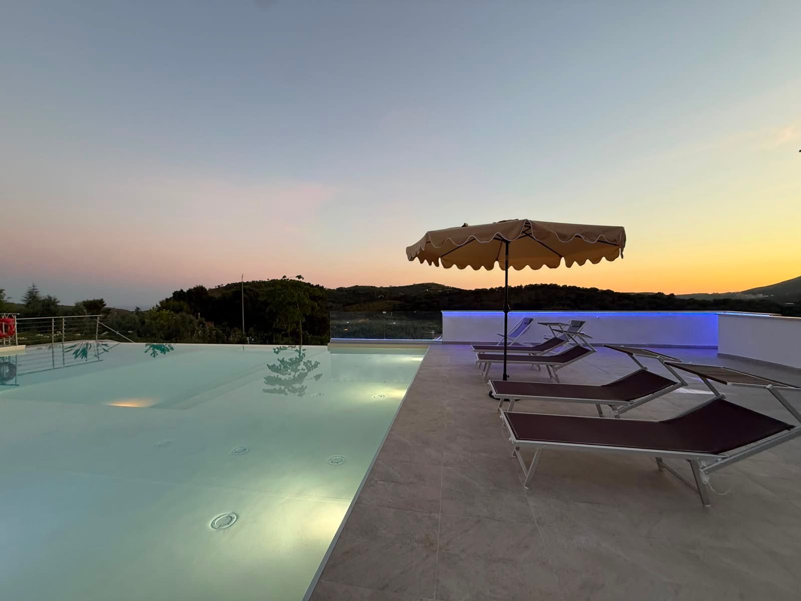 Piscina al tramonto con ombrellone