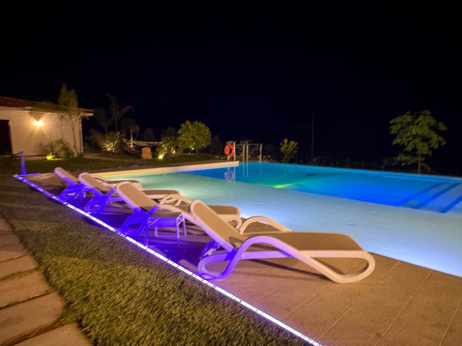 Lettini a bordo piscina illuminati di blu