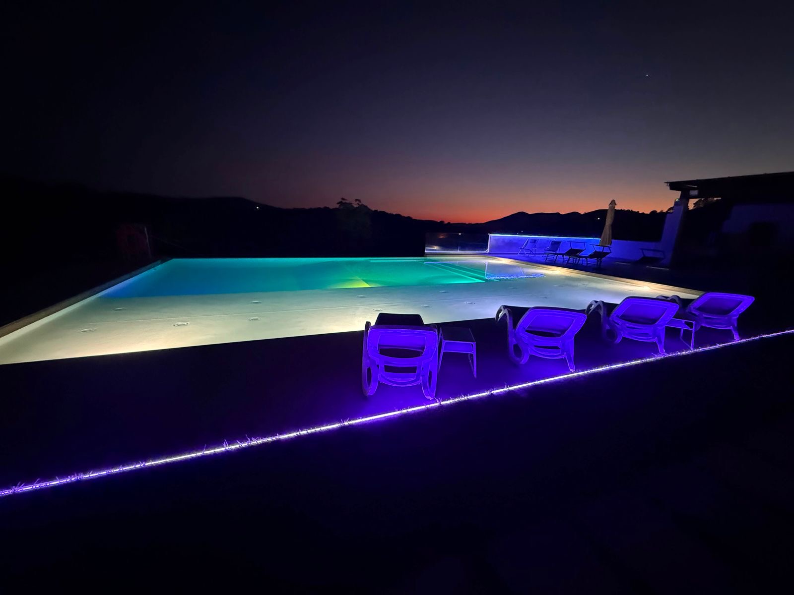 Piscina al tramonto con luci viola