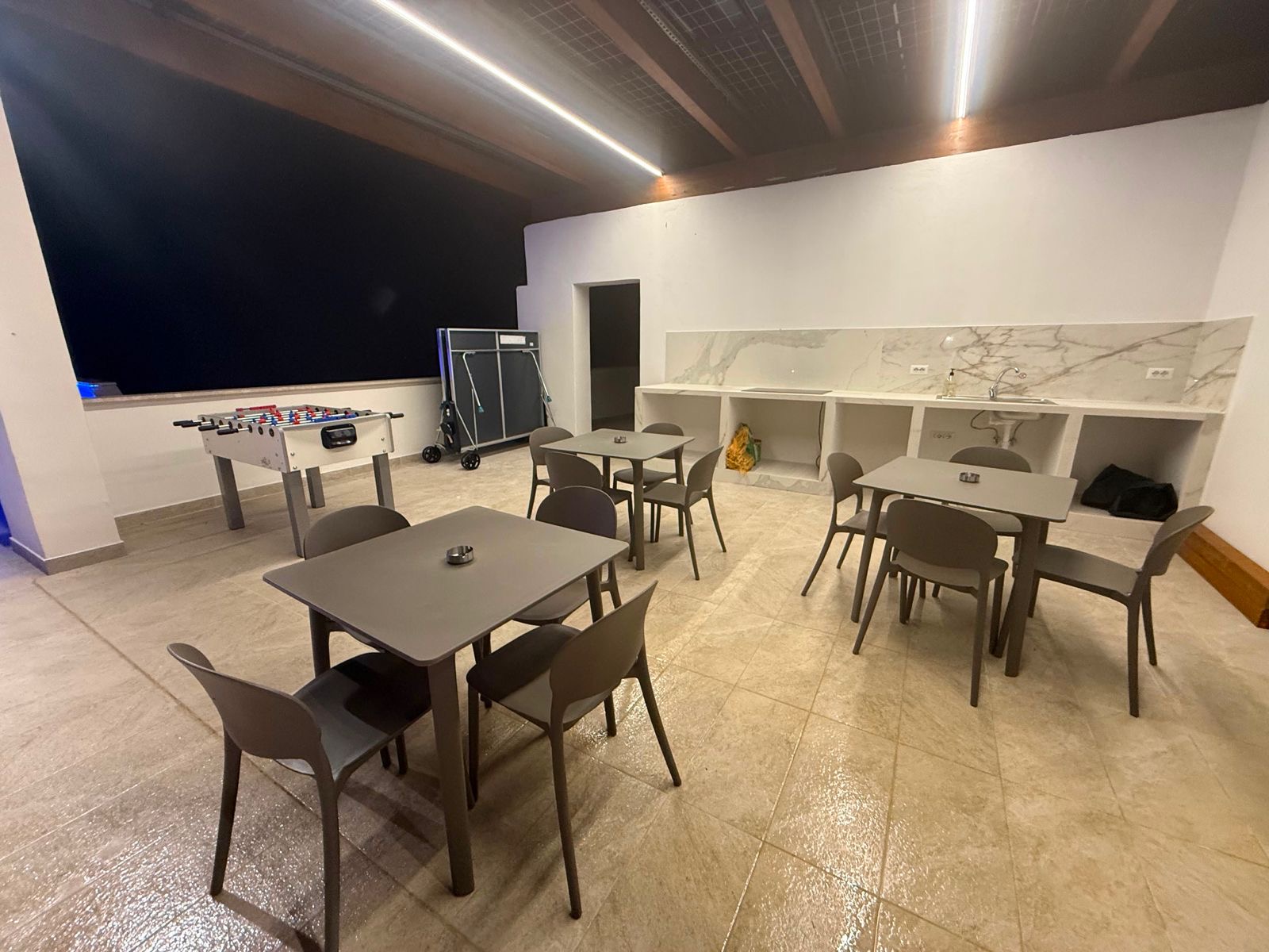 Sala giochi con calcio balilla, ping pong e angolo cottura