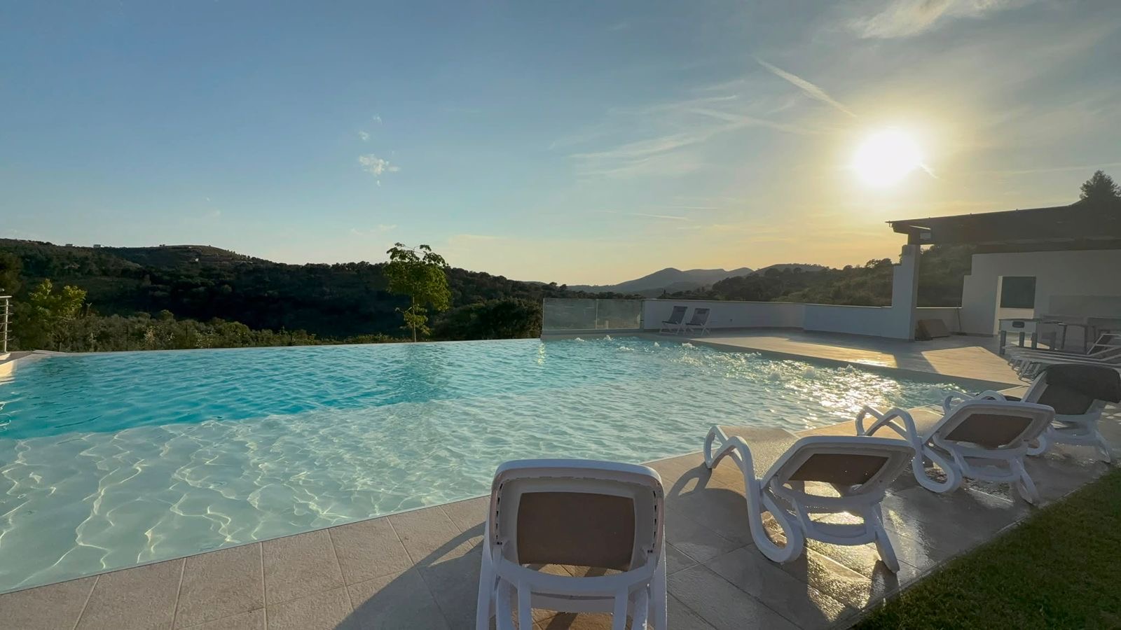 Piscina a sfioro con lettini al tramonto