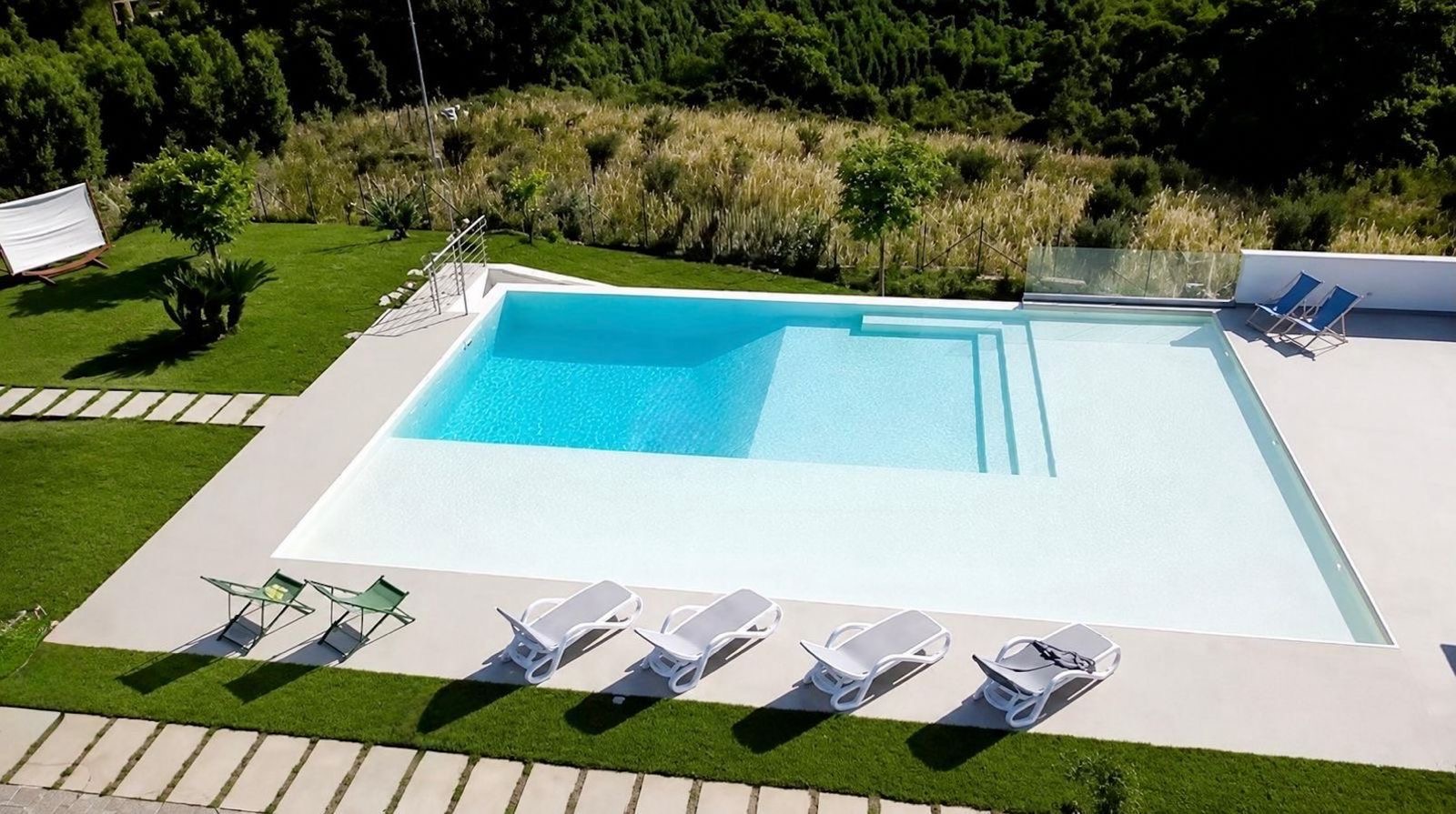 Vista aerea della piscina a sfioro tra il verde