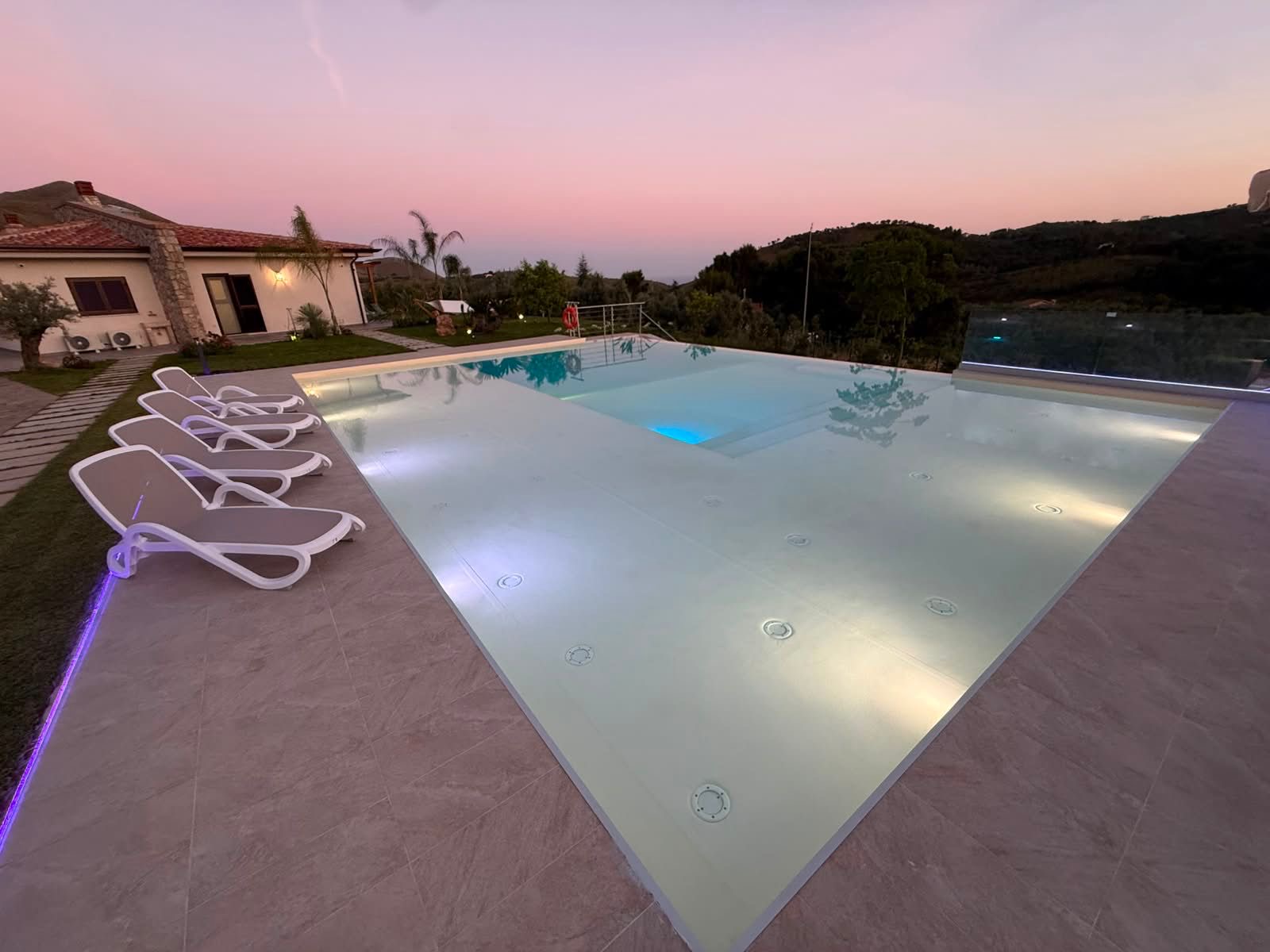 Piscina a sfioro con cielo rosa